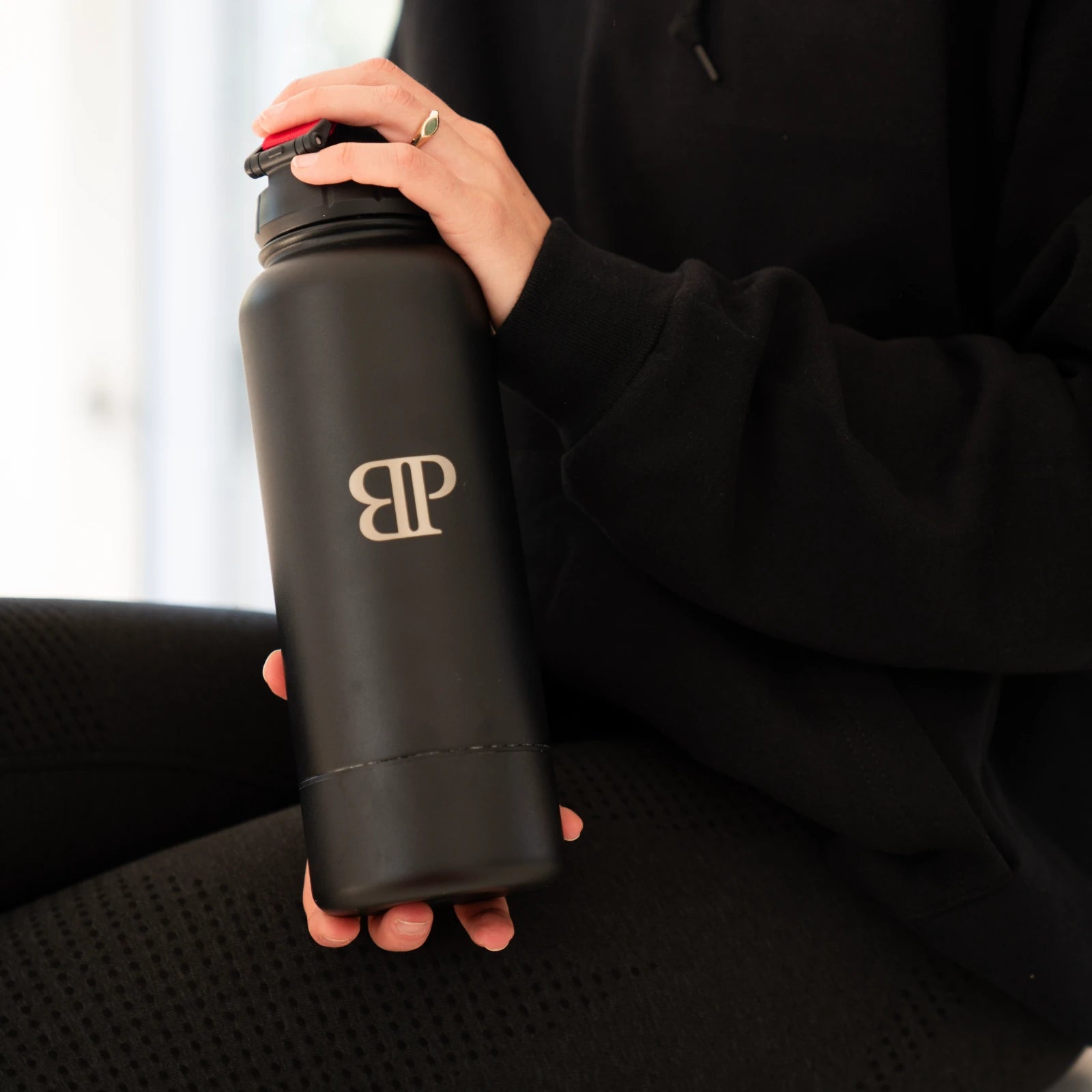 Schwarzer Bollaz Thermo Shaker mit graviertem BP Logo wird in der Hand gehalten, mattes Design und hochwertige Verarbeitung.